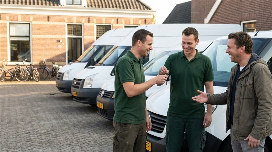 Het wagenpark van Kela: witte bestelbussen, verhuisbussen en een bakwagen op een rij, allemaal reclamevrij